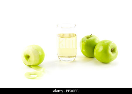 Trois pommes vertes et un verre de jus de pomme isolé sur fond blanc. Banque D'Images