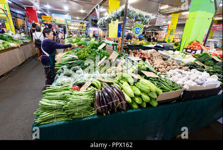 Titulaire d'un étal de légumes verts chinois organise à la populaire Rusty's Market sur Sheridan Street, Cairns, Queensland, Australie Grand Nord Banque D'Images