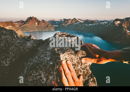 Les mains de l'homme jusqu'à l'escalade de la montagne de vie actif aventure voyage vacances extrême en Norvège Banque D'Images