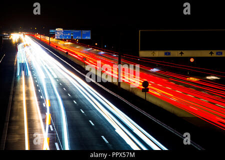 Le trafic de nuit sentiers dans le cadre d'une autoroute allemande, flou de mouvement, avec les camions, voitures et bus, en Allemagne, A3, Wiesbadener Kreuz Banque D'Images