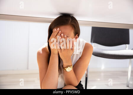 Businesswoman couvrant son visage tout en se cachant sous 24 Banque D'Images