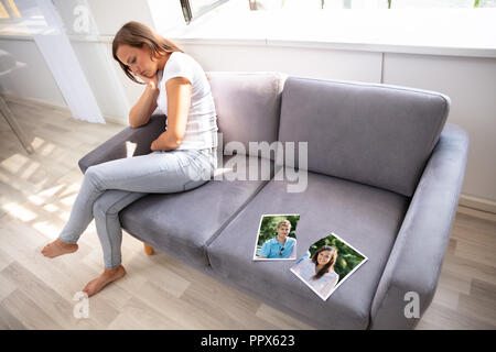 Lonely Woman Sitting on Sofa avec photographie déchirée Banque D'Images