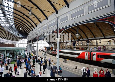 Les passagers qui attendent sur le quai de la gare dans la gare centrale de Newcastle avec des boutiques et des cafés à l'arrière, Newcastle-upon-Tyne, Tyne et Nous Banque D'Images