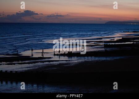 Hastings, East Sussex, Royaume-Uni. 28 septembre 2018. Météo au Royaume-Uni : le soleil se couche sur la colline au loin en laissant des teintes de bleu et d'orange dans le ciel et la mer. Coucher de soleil Hastings. Crédit photo: Paul Lawrenson / Alay Live News Banque D'Images