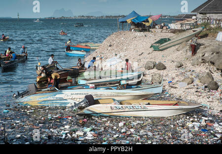 Taxi de l'eau des bateaux effectuent en océan plein de sacs en plastique, les bouteilles en plastique, polystyrène et autres ordures dans Semporna, Bornéo, Malaisie Banque D'Images