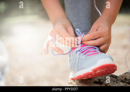 Des chaussures de course. Liage femme lacets dans le parc piscine Banque D'Images