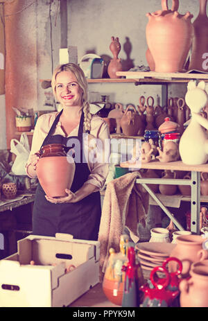 Portrait de femme sourire heureux Travailleur diligent poterie avec vaisselle en céramique dans les mains en studio Banque D'Images