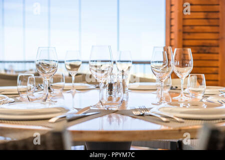 Table avec assiettes, verres et couverts prêt pour le déjeuner dans un restaurant élégant Banque D'Images