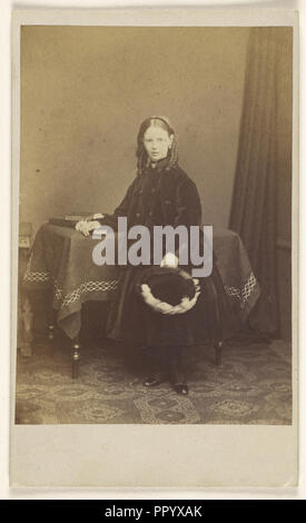 Jeune fille en boucles, debout, tenant un chapeau, posant son autre bras sur une table avec des livres sur le dessus ; Joseph Brown, britannique, active Banque D'Images