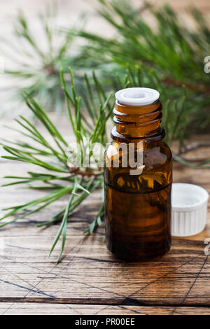 L'huile essentielle de cèdre et l'épinette dans de petites bouteilles en verre sur fond de bois. Selective focus Banque D'Images