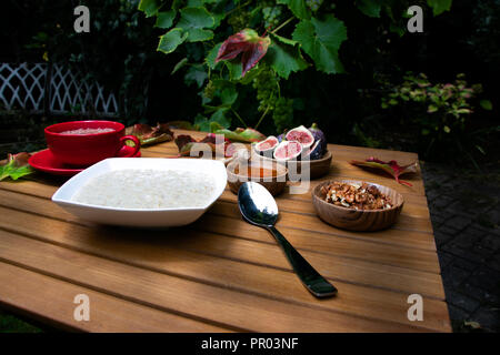 Petit-déjeuner rustique de l'automne bol de porridge, chocolat, figues dans apple orchard garden Banque D'Images