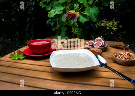 Petit-déjeuner rustique de l'automne bol de porridge, chocolat, figues dans apple orchard garden Banque D'Images