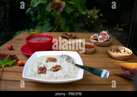 Petit-déjeuner rustique de l'automne bol de porridge, chocolat, figues dans apple orchard garden Banque D'Images