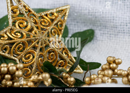 Golden Star brillant décor de Noël avec le gui d'or sur un fond de tissu blanc Banque D'Images
