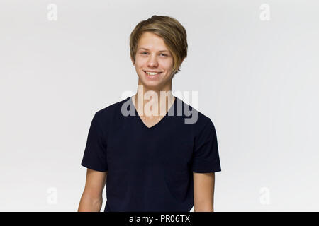 Happy smiling adolescent en bleu noir T-shirt contre fond blanc isolé, studio shot Banque D'Images