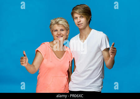 Heureux et souriant la mère et le fils dans une accolade et geste ok. Famille aimante Banque D'Images