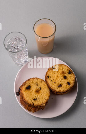 Tranches de gâteau fait maison, un verres d'eau de glace jus de fruits, sur fond gris clair, d''une télévision. Banque D'Images