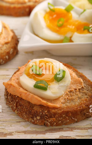 Sandwiches avec de la pâte de saumon et oeuf sur le fond en bois blanc Banque D'Images