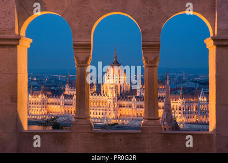 Le Parlement hongrois, la nuit, vue depuis les colonnes et les fenêtres de le Bastion des Pêcheurs, l'UNESCO World Heritage Site, Budapest, Hongrie, Europe Banque D'Images