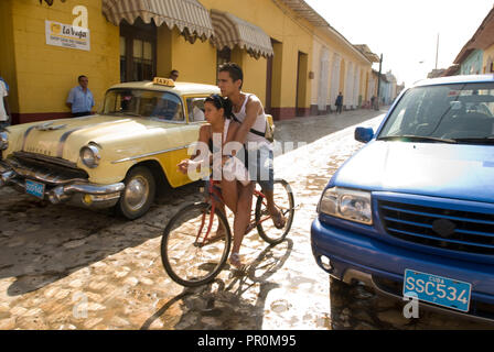 Jeune couple équitation un vélo dans les rues de galets de Trinidad Cuba Banque D'Images