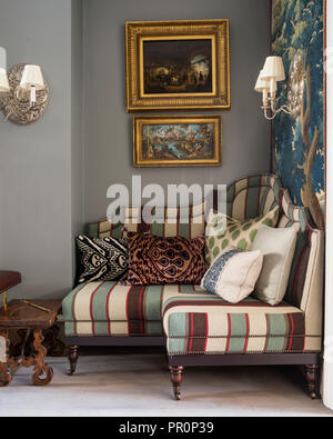 Les illustrations encadrées avec cadre doré 19e siècle tapisserie de verdure et Panneaux capitonnés banquette avec Andrew Martin stripe Banque D'Images