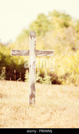 Vieille croix de bois dans un cimetière historique avec de beaux arbres remplis d'herbe et de l'expérience dans un cadre paisible Banque D'Images