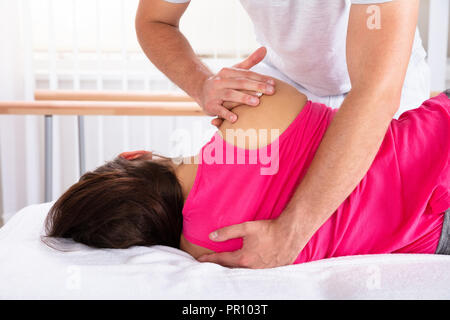 Close-up of a la main du thérapeute de massage de l'épaule pour femme Banque D'Images