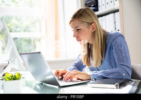 Young Businesswoman Using Laptop concentré sur le lieu de travail Banque D'Images