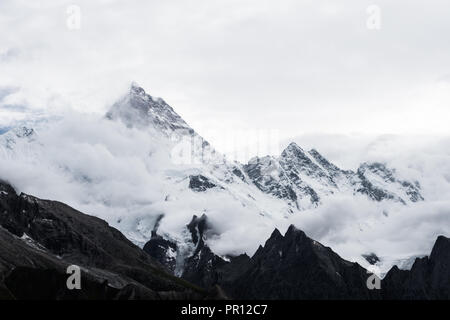 Masherbrum (K1) et Mandu peak apparaissent derrière les nuages, Galcier Baltoro, Goro II camping, Karakoram, Pakistan Banque D'Images