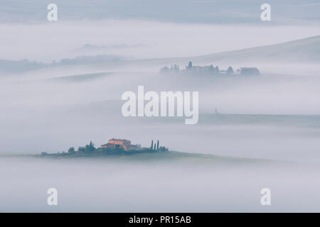 Brume matinale longue parmi les villas et fermes dans le Val d'Orcia, UNESCO World Heritage Site, Toscane, Italie, Europe Banque D'Images