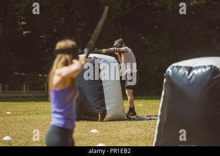 L'homme et la femme pratiquant le tir à l'arc au boot camp Banque D'Images