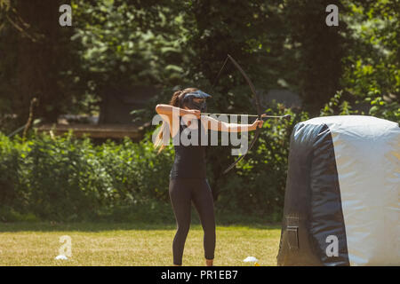 Woman practicing archery au boot camp Banque D'Images