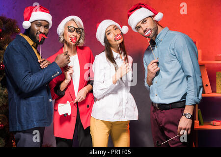 Multicultural businesspeople holding lèvres et des moustaches sur des bâtons à la nouvelle année partie de l'entreprise Banque D'Images