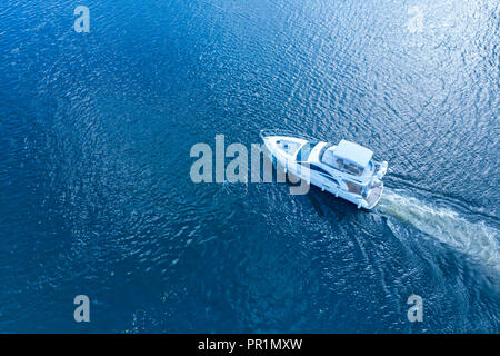 Course de bateaux à moteur par la rivière dans la lumière du soleil. Vue d'en haut Banque D'Images