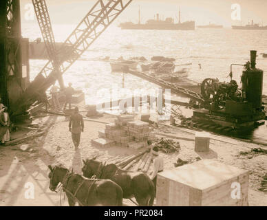 La construction de la jetée de Jaffa. Grues à l'œuvre sur le Quais de Jaffa. Effet d'éclairage arrière inhabituelle. 1934, Israël, Tel Aviv Banque D'Images