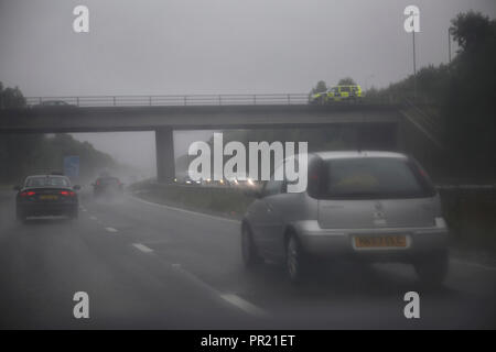 Trafic dans Heavy Rain sur M3 voiture de police sur le pont sud de l'Angleterre Banque D'Images