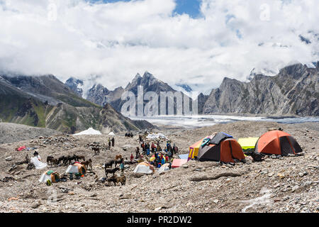 Les randonneurs et les porteurs à Goro II camping avant Masherbrum (K1) couvert de nuages, glacier du Baltoro, Karakoram, Pakistan Banque D'Images