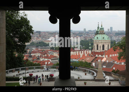 L'église Saint Nicolas (Kostel svatého Mikuláše) dans la place Malostranské se lève sur les toits de peu (Malá Strana) à Prague, République tchèque, représentée par l'escalier (schodiště Býčí Bull) conçu par l'architecte slovène Jože Plečnik et construit en 1929-1931. Les touristes visitant le jardin sur les remparts (Zahrada Na Valech) sont vus à l'avant-plan. Banque D'Images