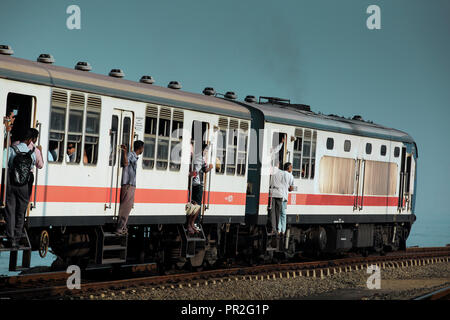 Les hommes sortir portes du train de banlieue bondé près de Colombo, Sri Lanka Banque D'Images