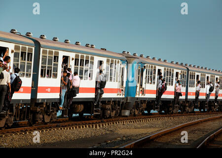 Les hommes sortir portes du train de banlieue bondé près de Colombo, Sri Lanka Banque D'Images