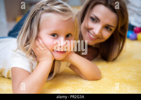 Tuteur à la recherche à l'adorable sourire de gosse de mains et en maternelle Banque D'Images