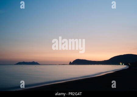 Coucher du soleil en descendant à Fondi (LT), Italie. À la plage. Obturation lente sans nuages. Calme mer plate avec obturation lente Banque D'Images