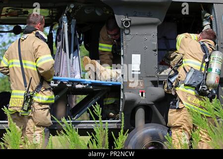 Les pompiers de Fort Bragg l'incendie et d'urgence évacuer une victime simulée d'un UH-60 Blackhawk hélicoptère pendant un scénario de formation d'urgence à Fort Bragg, Caroline du Nord, 25 juillet 2017. Les premiers intervenants en provenance de plusieurs domaines, l'ensemble de l'installation a réagi à l'incident en temps réel à mesure que le scénario d'une escalade. Banque D'Images