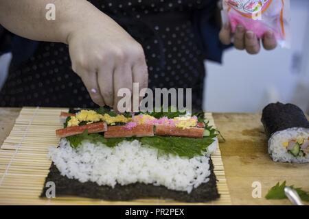 Sachiko Tamura, un chef avec l'Association de Promotion de l'alimentation de la ville Iwakuni, tops son sushi avec denbu, un poisson flake assaisonnement, lors d'un cours de cuisine japonaise à Santopia dans Otake, Japon, Juillet 25, 2017. Marine Corps Air Station Iwakuni résidents ont voyagé avec le programme d'adaptation culturelle de participer à la classe où ils ont appris à bien se préparer et cuisiner des sushis, tempura et un dessert au lait japonais. La classe a donné un but commun pour les participants de travailler ensemble et d'apprendre la cuisine japonaise des compétences qui peuvent être utilisées dans leur propre maison. Banque D'Images