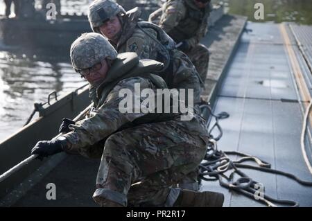 Les soldats de l'Armée active du 502e Multi Role Bridge Co., tirer sur des cordes pour aligner l'intérieurapt bridge bay articles ensemble. L'Armée américaine, les soldats d'active et de réserve d'active et de réserve avec des éléments marins à déployer, à construire et d'assembler un environ 320 mètres ruban amélioré flottante pont sur la rivière Arkansas pendant l'agression de la rivière 2017, à Fort Chaffee, Centre Manœuvre Ark., le 26 juillet 2017. Agression de la rivière 2017 est un combat prolongé de deux semaines d'entraînement tenue 15-28 juillet l'accent sur les compétences techniques, de divers membres de l'armée, qui a abouti à la construction d'une impr Banque D'Images