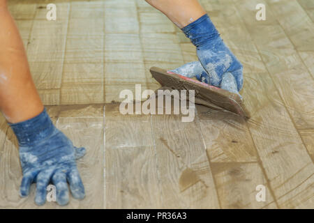 Des carreaux de faïence de couleur gris réparation nouvelle tuile coulis gris pour l'étape finale pour le plancher Banque D'Images