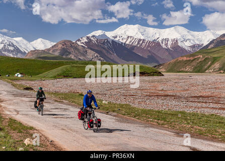 Les cyclistes sur la route du Pamir en ordre décroissant du Pamir dans la vallée de l'Alay distant au Kirghizistan. Banque D'Images