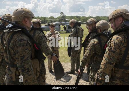 CAMP GRAYLING, Michigan - Marines des États-Unis avec la société Echo, 4e Bataillon de Reconnaissance, 4e Division de marines, Marines Réserve des Forces canadiennes, écouter une dernière brève avant de mener une helocast exercice au large d'un Marine américain Sikorsky SH-60 Seahawk de l'Escadron de Combat de mer 22 l'ombre au Camp d'entraînement aux Manœuvres conjointes Center, Michigan, lors de l'exercice Northern Strike 17, 31 juillet 2017. Helocasting est une technique utilisée dans l'air par petites unités et d'opérations spéciales pour l'insertion dans les zones militaires d'opérations. L'exercice Northern Strike est un bureau de la Garde nationale de formation parrainée par l'exercice qui unit publique Banque D'Images