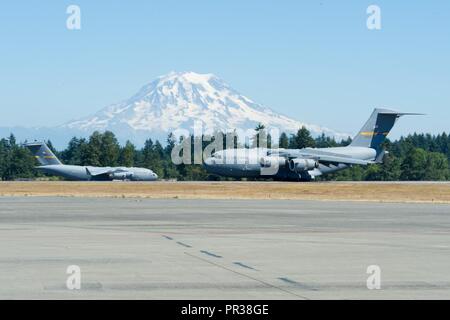 Un U.S. Air Force C-17 Globemaster III à partir de la 437e Escadre de transport aérien, d'une base commune Charleston, SC., taxis par le Mont Rainier après son arrivée à Joint Base Lewis-McChord, dans l'État de Washington, le 31 juillet 2017, à l'appui de la mobilité d'un tuteur. Plus de 3 000 soldats, marins, aviateurs, marines et les partenaires internationaux ont convergé sur l'état de Washington à l'appui de la mobilité d'un tuteur. L'exercice est destiné à tester les capacités des Forces aériennes de la mobilité La mobilité mondiale rapide pour exécuter des missions dans des environnements dynamiques, contestée. Guardian Mobility est le premier ministre de l'Air Mobility Command, offrant la possibilité d'exercice Banque D'Images