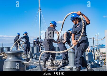 CAIRNS, Australie (16 août 2000 1, 2017) le soulèvement des marins des amarres en mer au cours d'une ancre et de détails que le navire de débarquement amphibie USS Ashland dock (LSD 48) Départ de port. Ashland, partie du Bonhomme Richard Expeditionary Strike Group (ESG), a rendu visite à Cairns à l'avance les relations de l'Australie aux États-Unis, après avoir participé à l'exercice d'entraînement bilatéral Talisman Saber. Au cours de la visite, marins et soldats ont participé à des projets de relations communautaires et de l'expérience de la culture de la ville historique. Banque D'Images